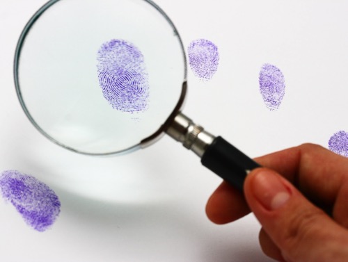 Magnifying glass examining a fingerprint
